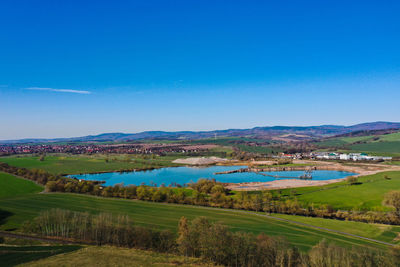 Scenic view of agricultural landscape against blue sky