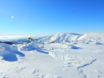 Scenic view of snowcapped mountains against clear blue sky