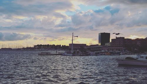 Panoramic view of sea and buildings against sky during sunset