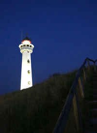 Low angle view of lighthouse amidst buildings against sky