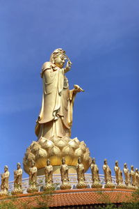 Low angle view of statue against blue sky