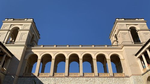 Low angle view of historical building against clear blue sky