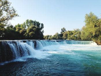 Scenic view of waterfall against clear sky