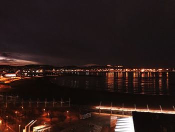 Illuminated cityscape against sky at night