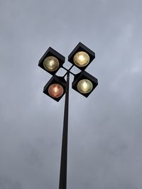 Low angle view of illuminated street light against sky