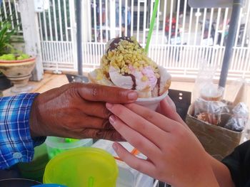 Midsection of woman holding ice cream on table