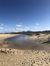 Scenic view of beach against blue sky