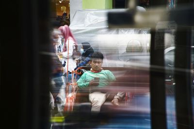Blurred motion of man seen through glass window