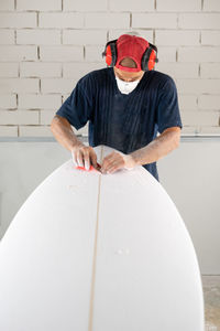 Surfboard modeling workshop - man perfecting the modeling of a surfboard