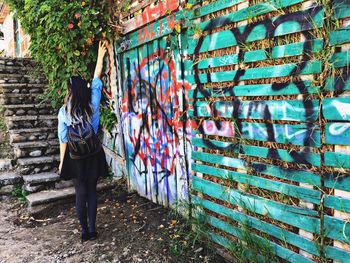 Rear view of woman standing by tree