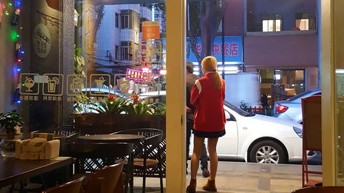 Rear view of woman on city street at night