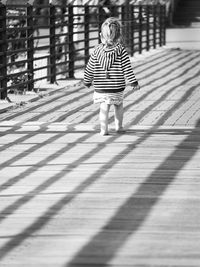 Rear view of girl walking on footpath