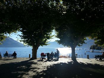People sitting at beach against sky
