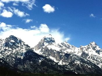 Scenic view of snowcapped mountains against blue sky