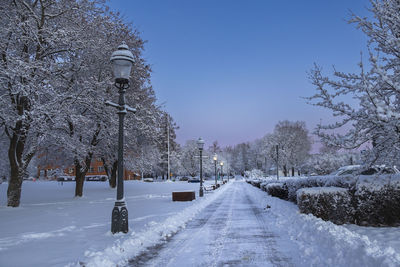 Snow covered field against clear sky