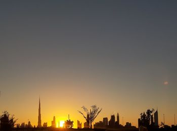 Silhouette of buildings against sky during sunset
