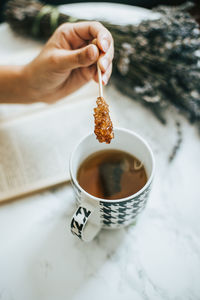 High angle view of person holding tea cup on table