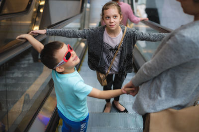 Family standing on escalator