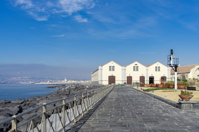 Building by sea against blue sky