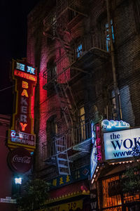 Low angle view of text on illuminated building at night