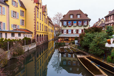 Canal amidst buildings against sky