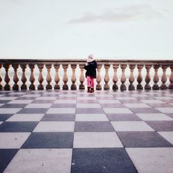 Rear view of woman standing on railing