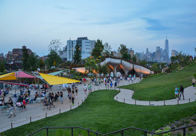 Group of people in park against buildings in city