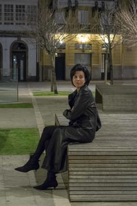 Portrait of a smiling woman sitting against building