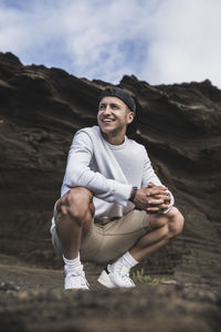 Portrait of smiling young man sitting on land