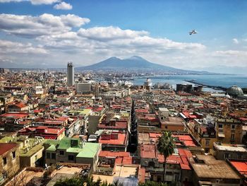 High angle view of townscape by sea against sky