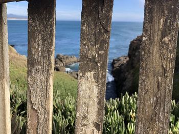 Scenic view of sea against sky seen through fence