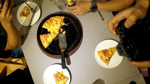 Cropped image of friends having pizza in restaurant