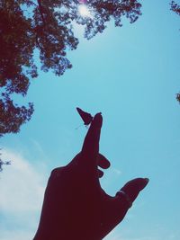 Low angle view of woman against clear blue sky