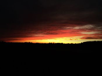 Silhouette landscape against sky at sunset