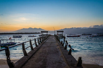 Pier on sea against sky during sunset