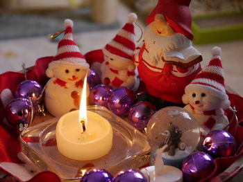 Lit candle by christmas decoration