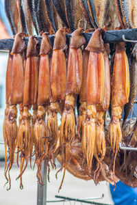 Hanging smoke-dried calamari in a fish market smoked with hardwood wood chips in a smoker