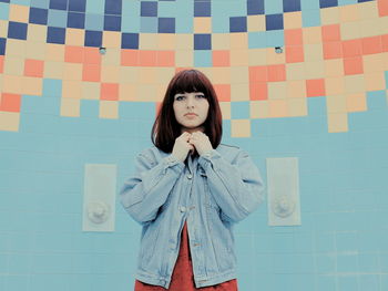 Portrait of woman standing against wall