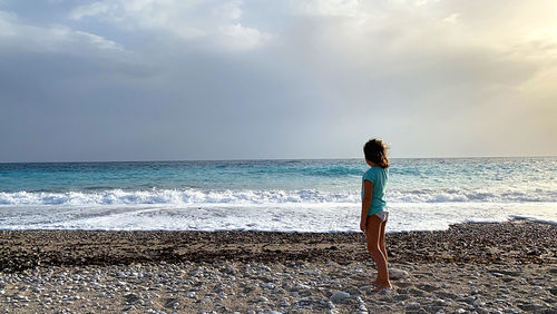 Full length of man standing on beach against sky