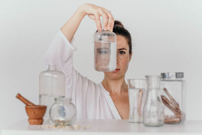 Scientist holding bottle against white background