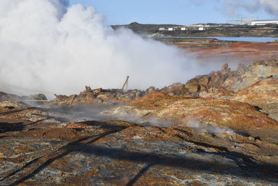 Panoramic view of waves breaking on shore against sky