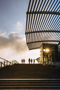 Low angle view of people on staircase against sky