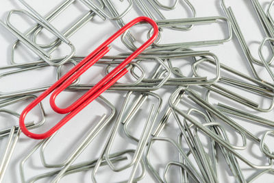 Full frame shot of metallic paper clips on table