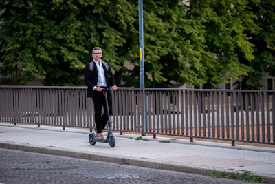 Full length of man skateboarding on railing against trees