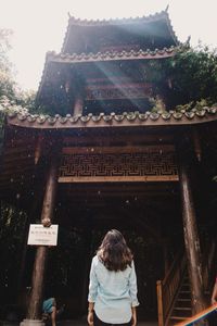 Rear view of woman standing against temple