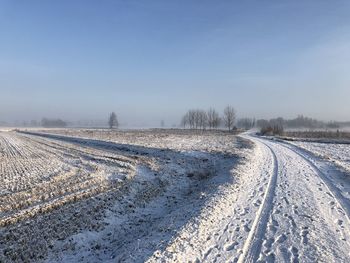 Snow covered field against sky