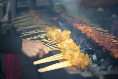 Person preparing food on barbecue grill