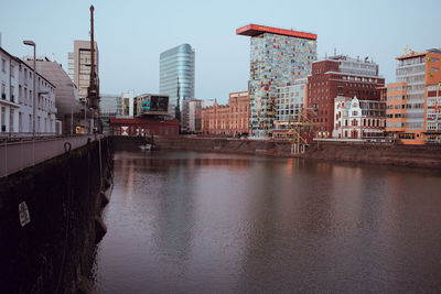 River by buildings against sky in city