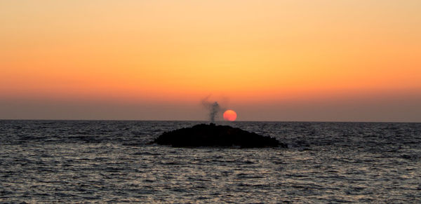 Scenic view of sea against orange sky