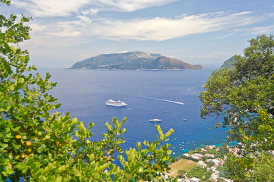 High angle view of sea by mountains against sky